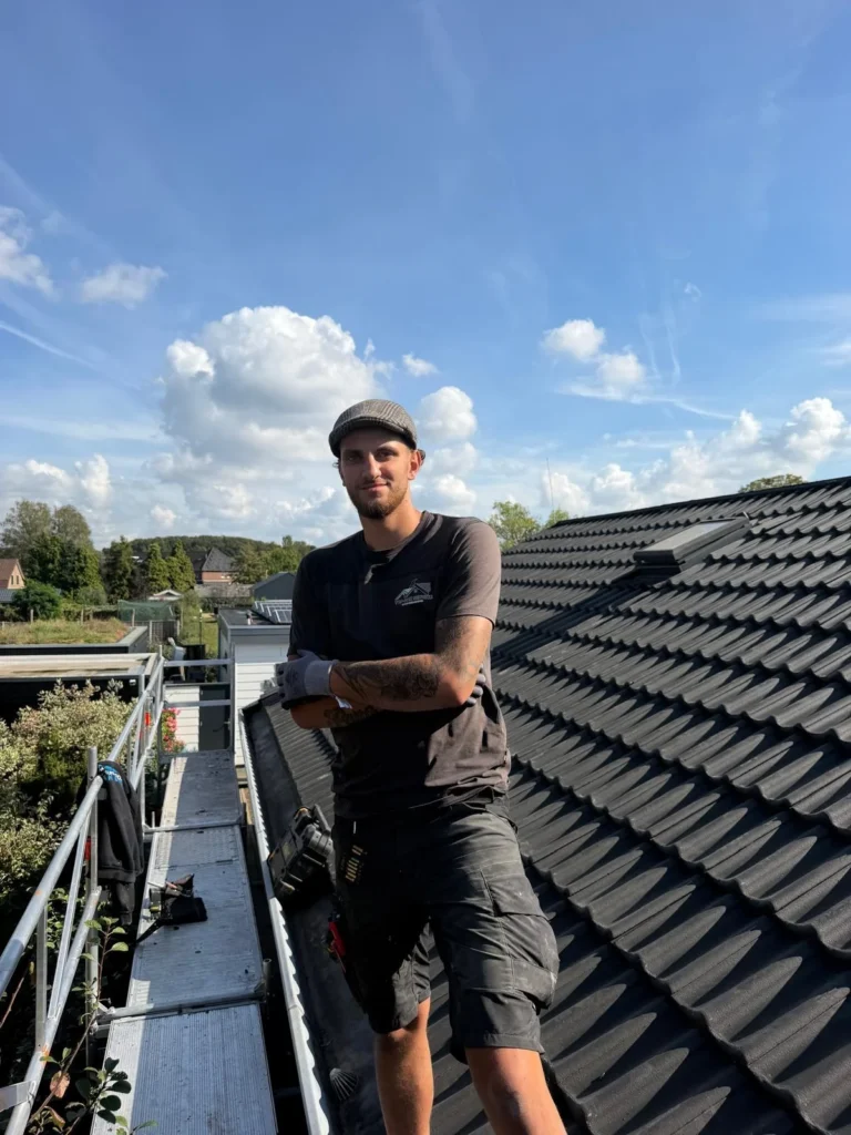 Dakdekker poseert op de steiger naast een nieuw pannendak in Lunteren